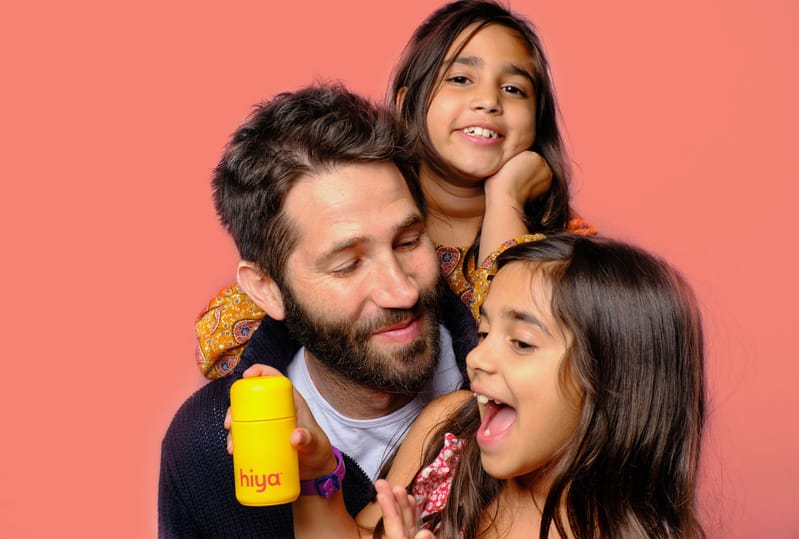 Two daughters and their dad hold their hiya vitamins