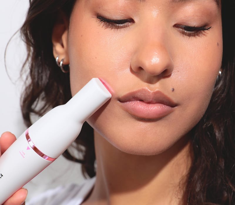 Woman using Pluxy facial hair removal device