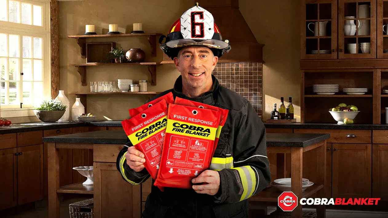 firefighter holding up Cobra Blanket; emergency thermal blanket
