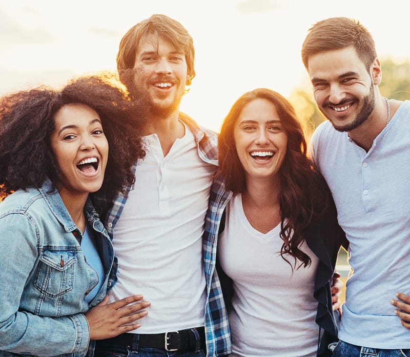 Happy group of friends with white teeth after using Laughland teeth whitening